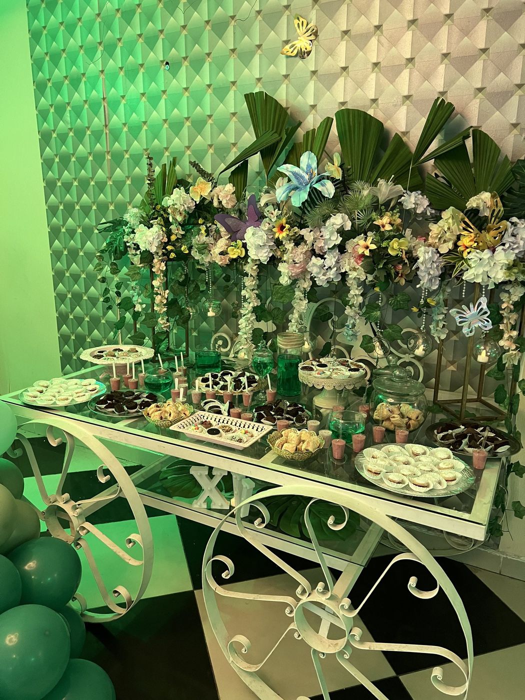 Carro de postres decorado con flores y mesa de dulces