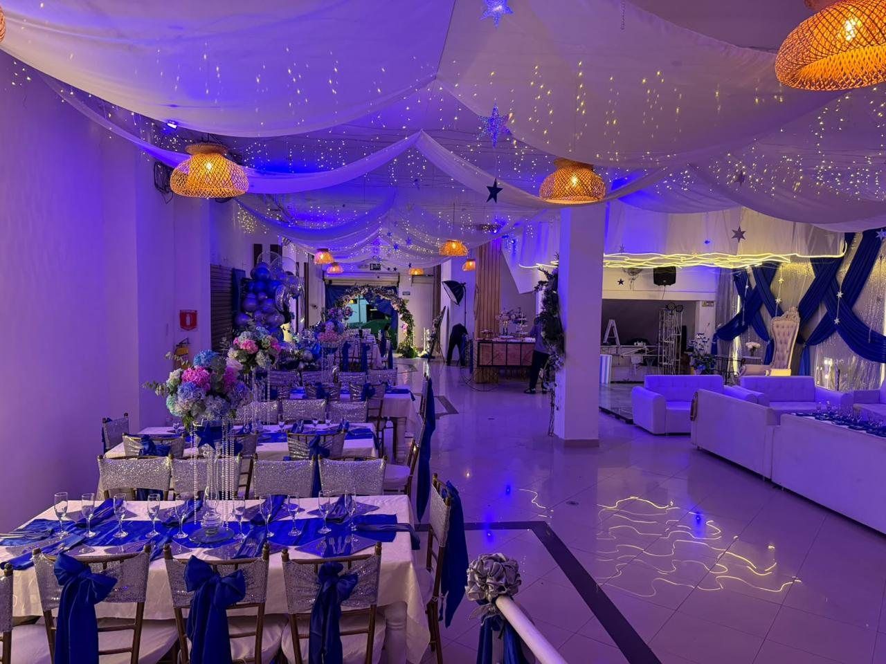 Salón con mesas largas montadas para un evento institucional